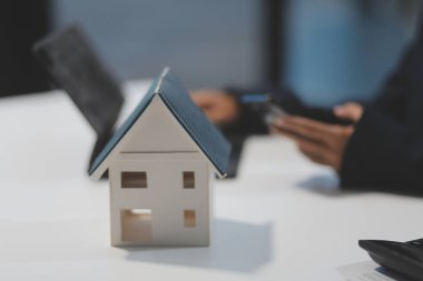 Real estate agents explain models of housing estates in projects to elaborate to clients, explaining and presenting information about homes and purchasing loans. Real estate trading concept.