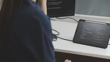 Kadın tasarımcı elinde tablet tutuyor ve ofiste dijital tabletini kullanıyor.