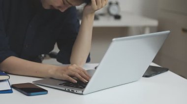 Ofisteki dizüstü bilgisayarda çalışan genç kadın..