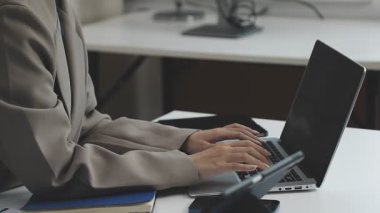 Ofiste dizüstü bilgisayarda yazan bir işadamı.