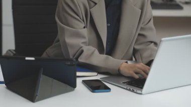 Modern ofiste dizüstü bilgisayarla çalışan genç bir iş kadını..