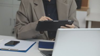 Ofisinde not defteri olan takım elbiseli bir kadın.