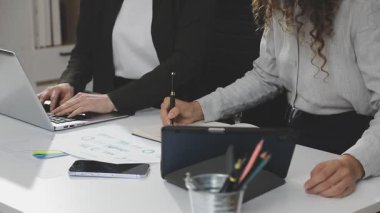 Genç iş kadını ofiste dizüstü bilgisayarla çalışıyor..