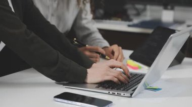 Modern ofiste dizüstü bilgisayarla ve finansal belgelerle çalışan iş adamlarının kapatılması