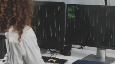 Evde veri kodu olan bilgisayarda çalışan genç bir kadın..