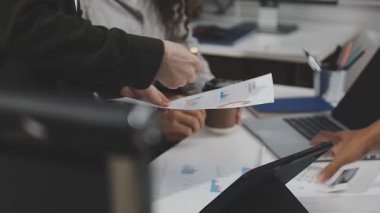 İş adamları masadaki mali tabloları tartışıyor..