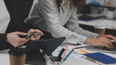 Genç iş adamları modern ofiste projeleri üzerinde çalışıyorlar..