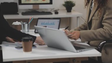 Dizüstü bilgisayarı ve kupası olan genç bir kadın.