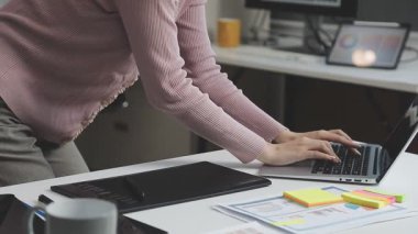 İş kadını ofiste dizüstü bilgisayar ve akıllı telefonla çalışıyor..