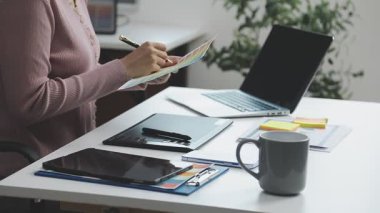 Tablet ve dizüstü bilgisayarla çalışan genç bayan tasarımcı