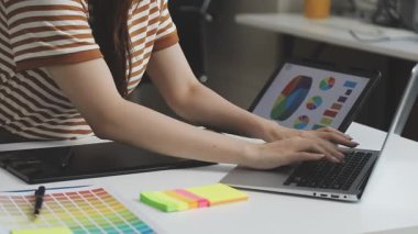Genç tasarımcı kadın grafik renk numunesi ve stylus ile ev ofisteki bilgisayar tabletinde çalışıyor.