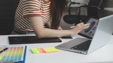 Bilgisayarı ve tableti olan genç bir kadın.