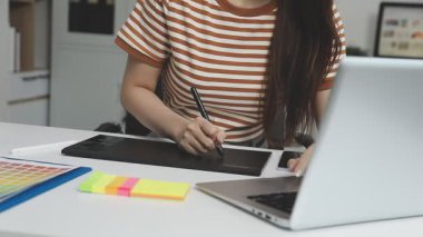 Genç bayan tasarımcı ofiste çalışıyor.