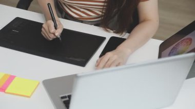 Dijital tablet kullanan ve ofisinde çalışan genç tasarımcı kadın tasarımcı..