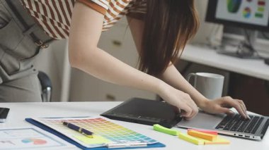 Stüdyoda bilgisayar üzerinde çizim yapan kadın tasarımcı