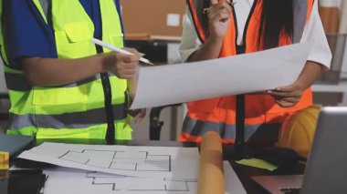 Ofiste çalışan mühendis ya da mimar ekibi inşaat ya da inşaat alanında bir planla çalışıyor. Planlama projesi üzerinde çalışan mühendis ya da mühendis.