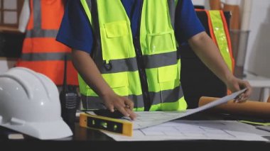 İnşaat alanındaki masanın planlarıyla çalışan mühendis. İnşaat mühendisi, mühendislik, inşaat endüstrisi, mühendislik konsepti. seçici odak.