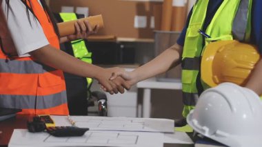 İnşaat mühendisi ya da mimar arka planda ekiple inşaat alanında çalışıyor..