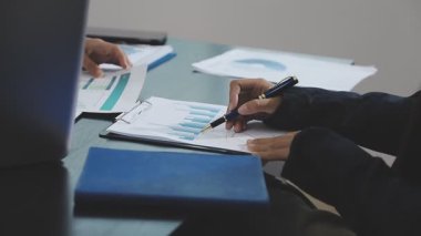 İşadamı eli dijital tablet kullanıyor ve ofisteki kağıda rapor yazıyor..