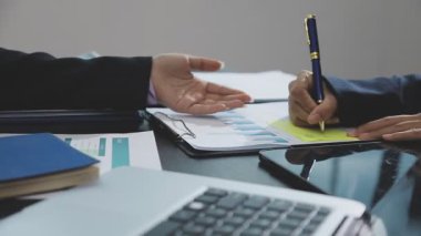 Genç iş kadını ofiste dizüstü bilgisayarla çalışıyor.