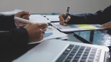 Masada finansal tablolar ve dizüstü bilgisayarla çalışan iş adamı..