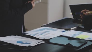 Bir iş adamının elinde dizüstü bilgisayar ve kalemle bir belgeyi tutarken görüntüsü.