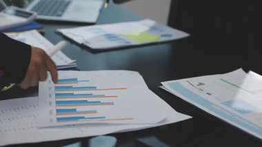 Modern ofiste belgelerle çalışan genç iş adamları.