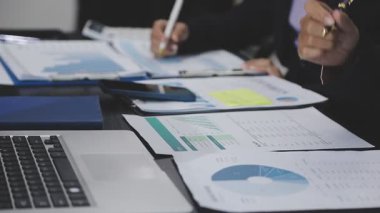 İşadamı elinde kalemle kağıt üzerinde yazı yazıyor.