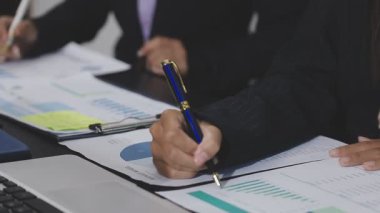 Ofisteki iş adamları, mali belgeler ve belgelerle çalışan iş adamları.