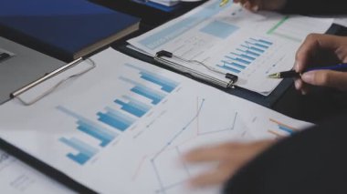 İş adamları modern ofiste toplantının mali istatistiklerini ve analizini tartışıyor.