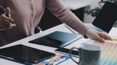 Genç bayan girişimci ofiste dizüstü bilgisayar kullanarak çalışıyor.