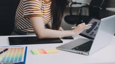 Ofiste dizüstü bilgisayarıyla çalışan genç bir kız..