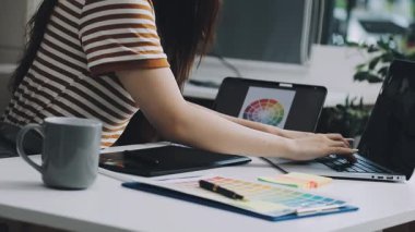 Ofisteki masada dizüstü bilgisayarı ve kahvesi olan genç bir kız.