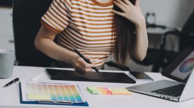 Genç tasarımcı ofiste bilgisayarla çalışıyor..