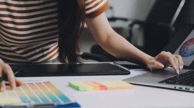 Genç Asyalı kadın tasarımcı ofiste çalışıyor.