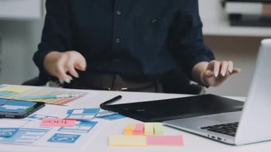 Genç tasarımcı iş yerinde bir tabletle çalışıyor