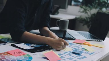 Ofis masasında dijital tabletle çalışan yaratıcı tasarımcı