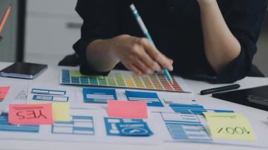 Genç bayan tasarımcı ofiste proje üzerinde çalışıyor.