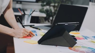 Tasarımcı ofisteki masada dizüstü bilgisayarla çalışıyor..