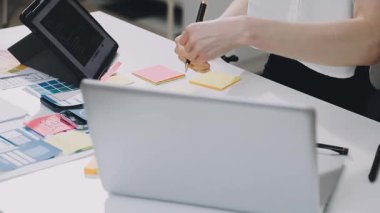 Genç bayan girişimci ofiste dizüstü bilgisayarla çalışıyor..