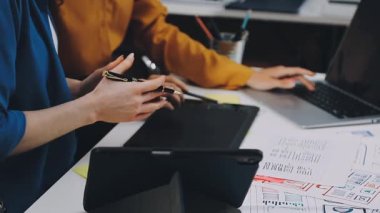 Genç tasarımcı ofiste dizüstü bilgisayarla çalışıyor
