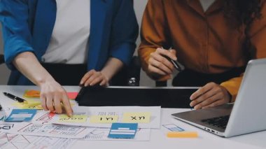 Ofiste proje üzerinde çalışan genç iş kadınları.