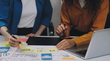 Genç iş ekibi yeni proje ve dizüstü bilgisayarla çalışıyor