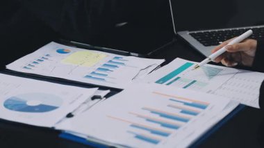 İşadamı dizüstü bilgisayar ve hesap makinesiyle finansal tabloları analiz ediyor.