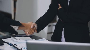 İş ekibi el sıkışıyor, ofiste iş toplantısı var..