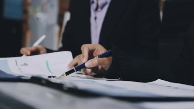 Genç adam iş yerinde kağıda yazı yazıyor.