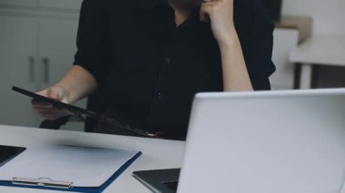 Ofiste akıllı telefon kullanan bir kadın.