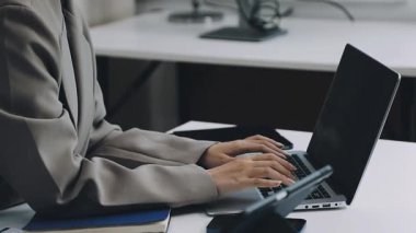 Ofiste dizüstü bilgisayarda çalışan genç bir iş adamı.