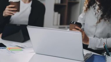 Ofiste dizüstü bilgisayarıyla çalışan genç bir kadın.