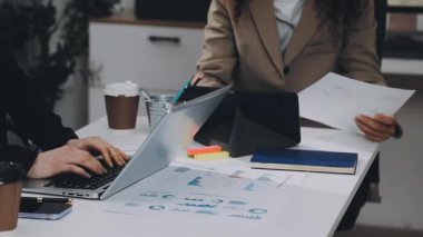 Modern çatı katında iş arkadaşları ve kahve ile birlikte dizüstü bilgisayarda çalışan iş adamları.